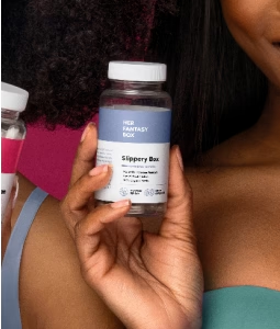 Woman holding a Her Fantasy Box Slippery Box supplement bottle