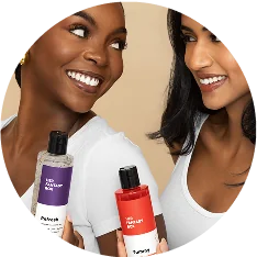 Two women smiling and holding Her Fantasy Box Refresh and Yummy body wash products.
