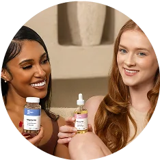 Two women smiling and holding Her Fantasy Box Slippery Box and Renew Her oil products.